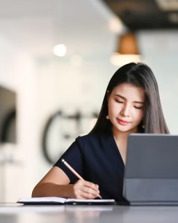 A girl stiing infront of laptop